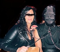 Dominatrix with leashed and masked sub